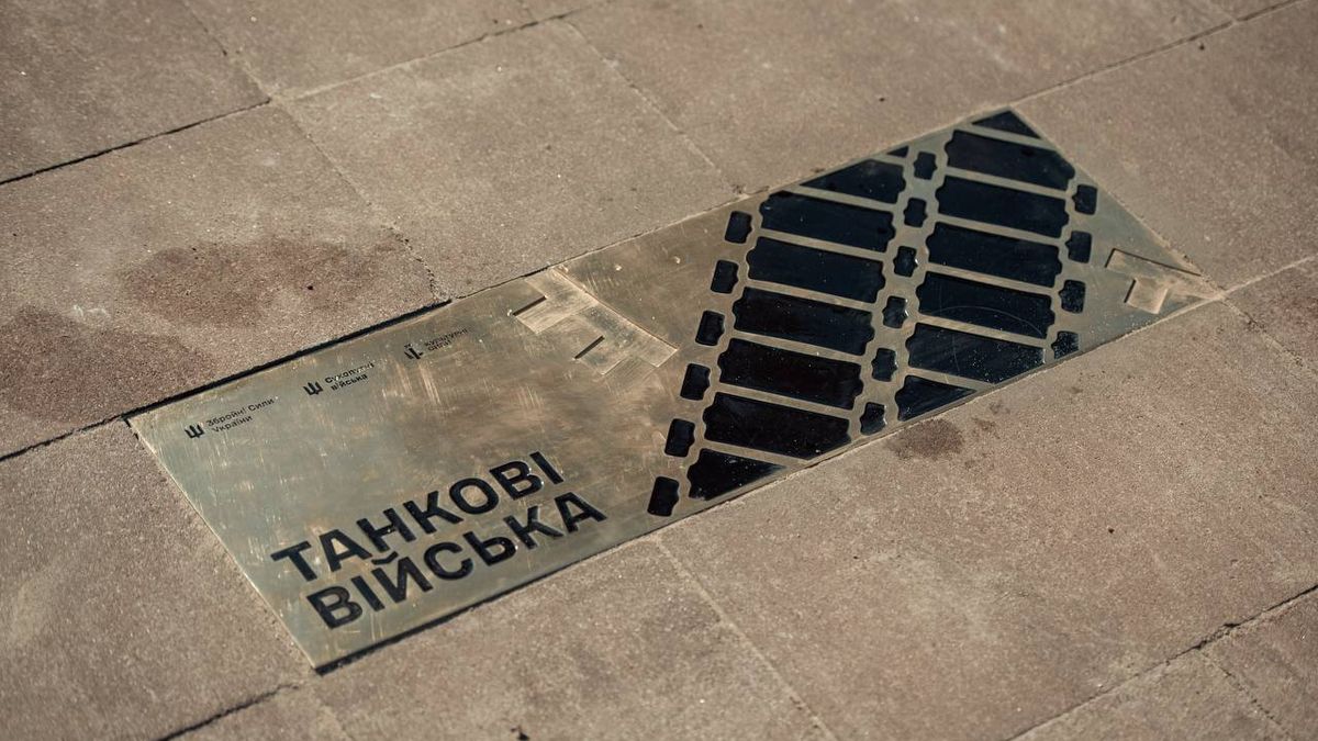 Металева табличка, вмонтована у тротуар, із написом «Танкові війська»
