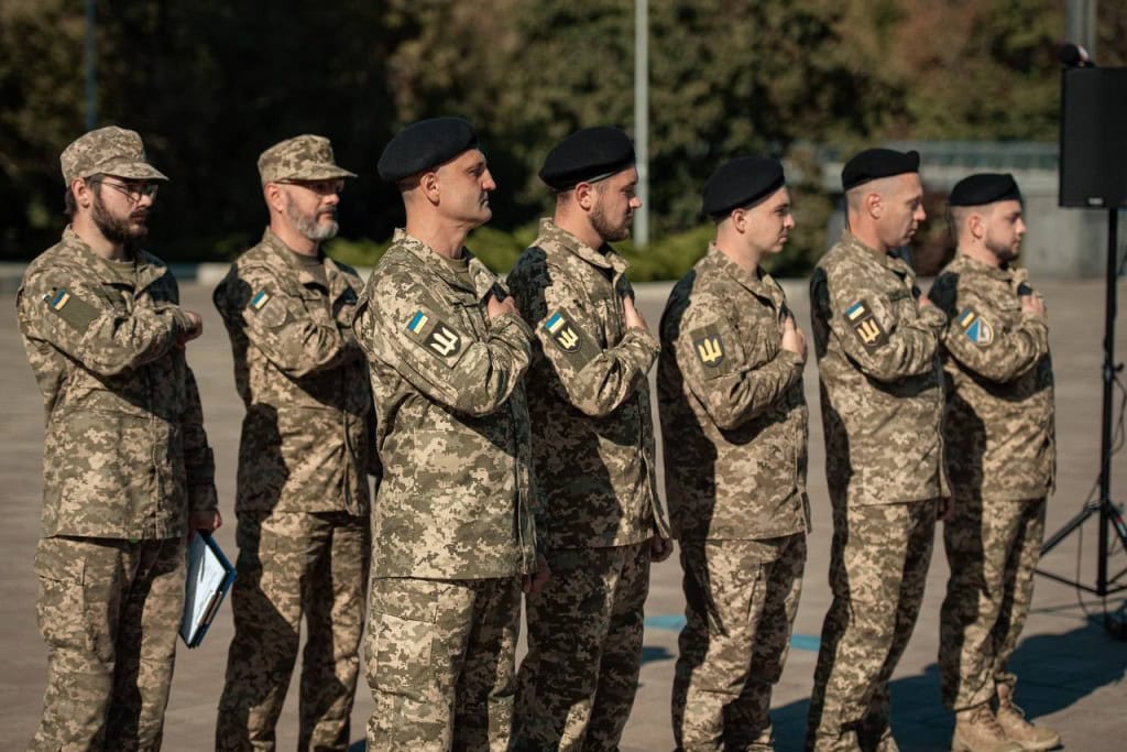 На Алеї захисників у Києві відкрили пам’ятний знак воїнам-танкістам Група українських військових у камуфляжній формі стоїть у шерензі, поклавши руки на серце