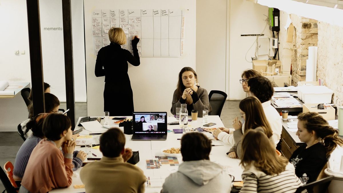 Група учасників сидить за столом, обговорюючи ідеї