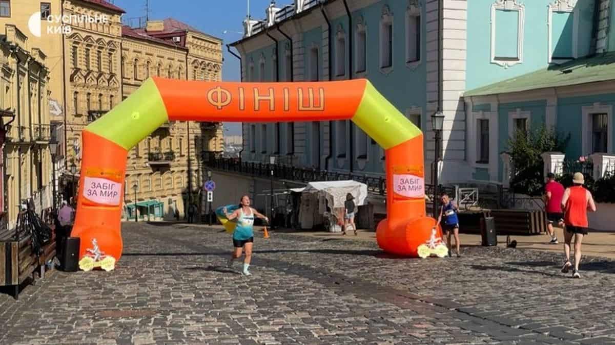 Фінальний знімок після забігу з надувностроєм "Фініш" у центрі Києва, на тлі історичних будівель та яскравих учасників.