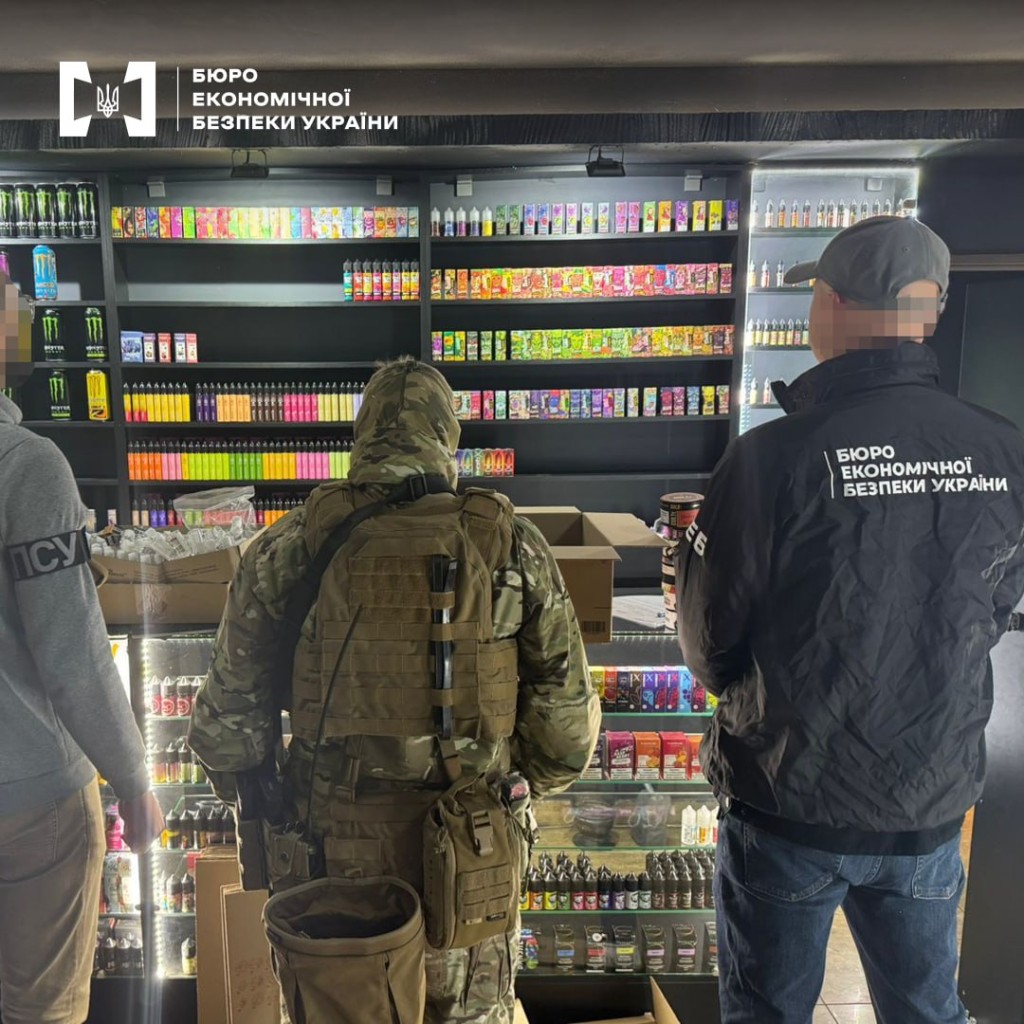 Правоохоронці стоять перед стендом із вейпами