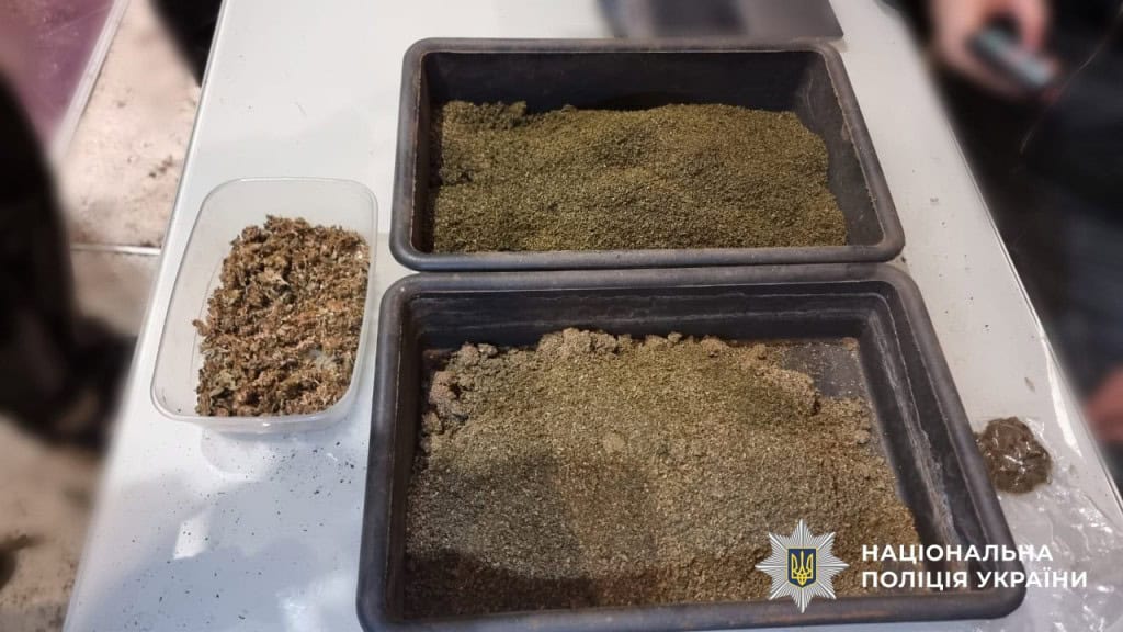 Наркотичні речовини лежать в двох чорних контейнерах і одному прозорому, які стоять на білому столі