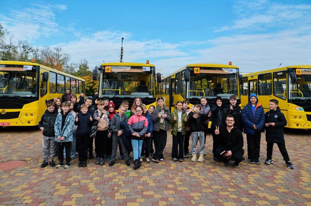Борщагівка та ще дев’ять громад отримали нові шкільні автобуси Зо два десятки дітей стоять біля нових шкільних автобусів