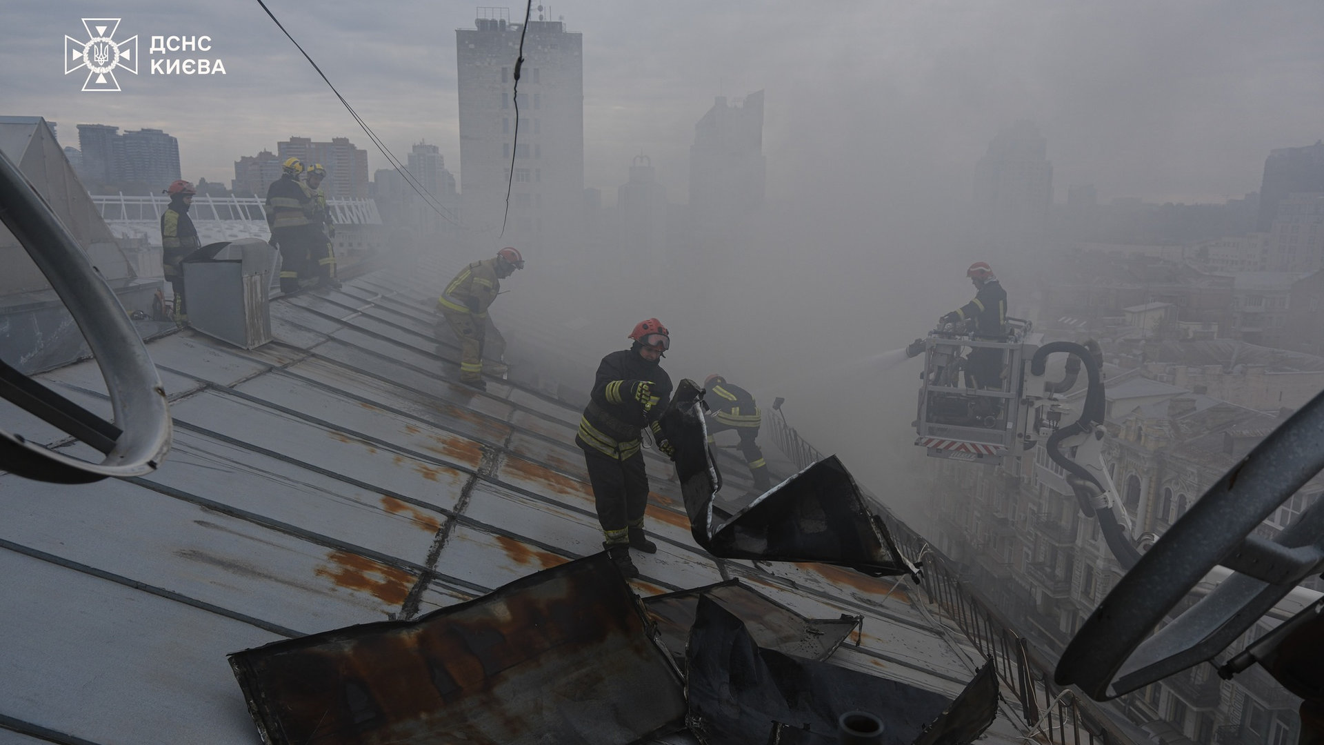 Пожежники стоять в диму на даху київської багатоповерхівки і борються із вогнем