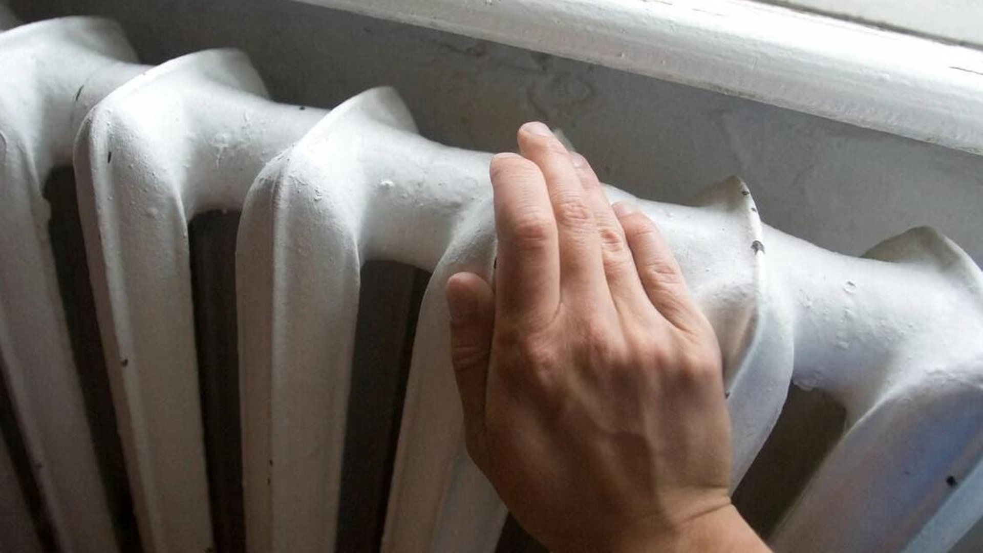 Рука, яка торкається до батареї