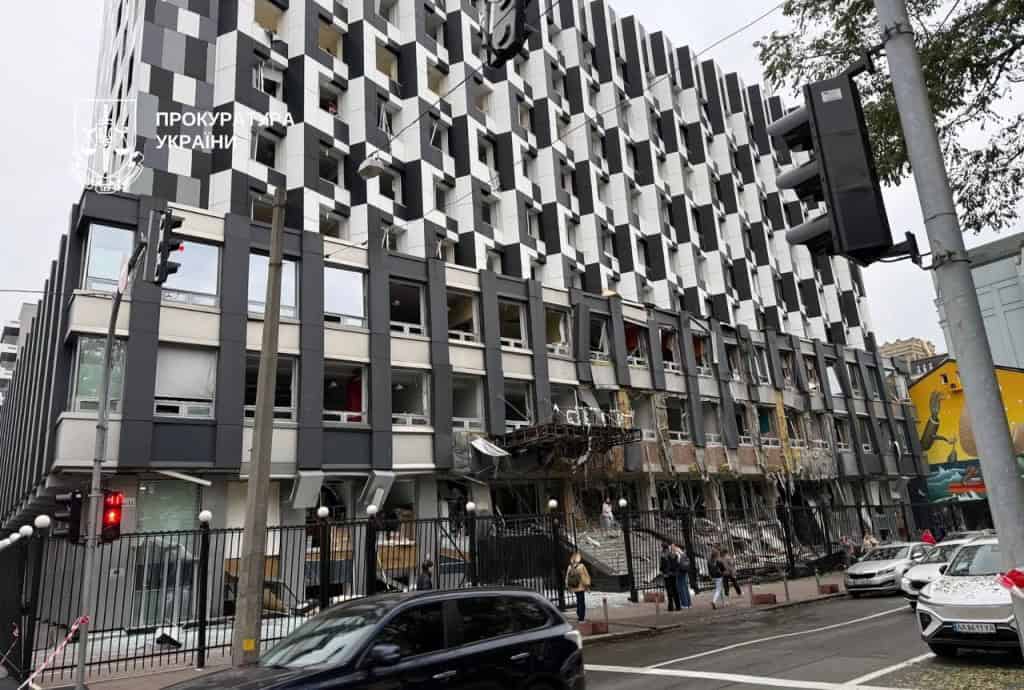 Сучасна будівля з пошкодженим фасадом і вибитими шибками після атаки