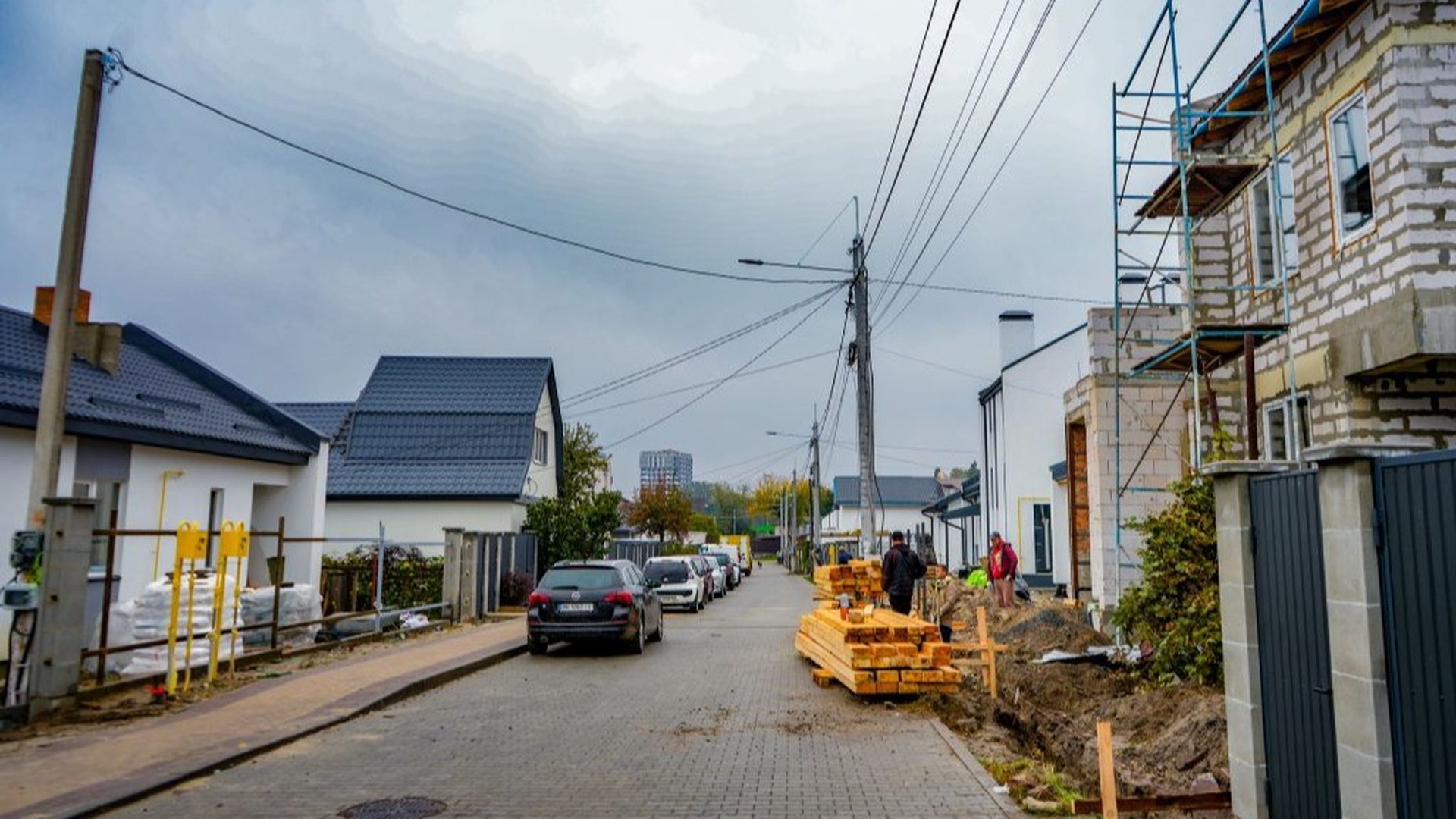 Вигляд упорядкованої вулиці з новими будинками та будівельними матеріалами вздовж дороги