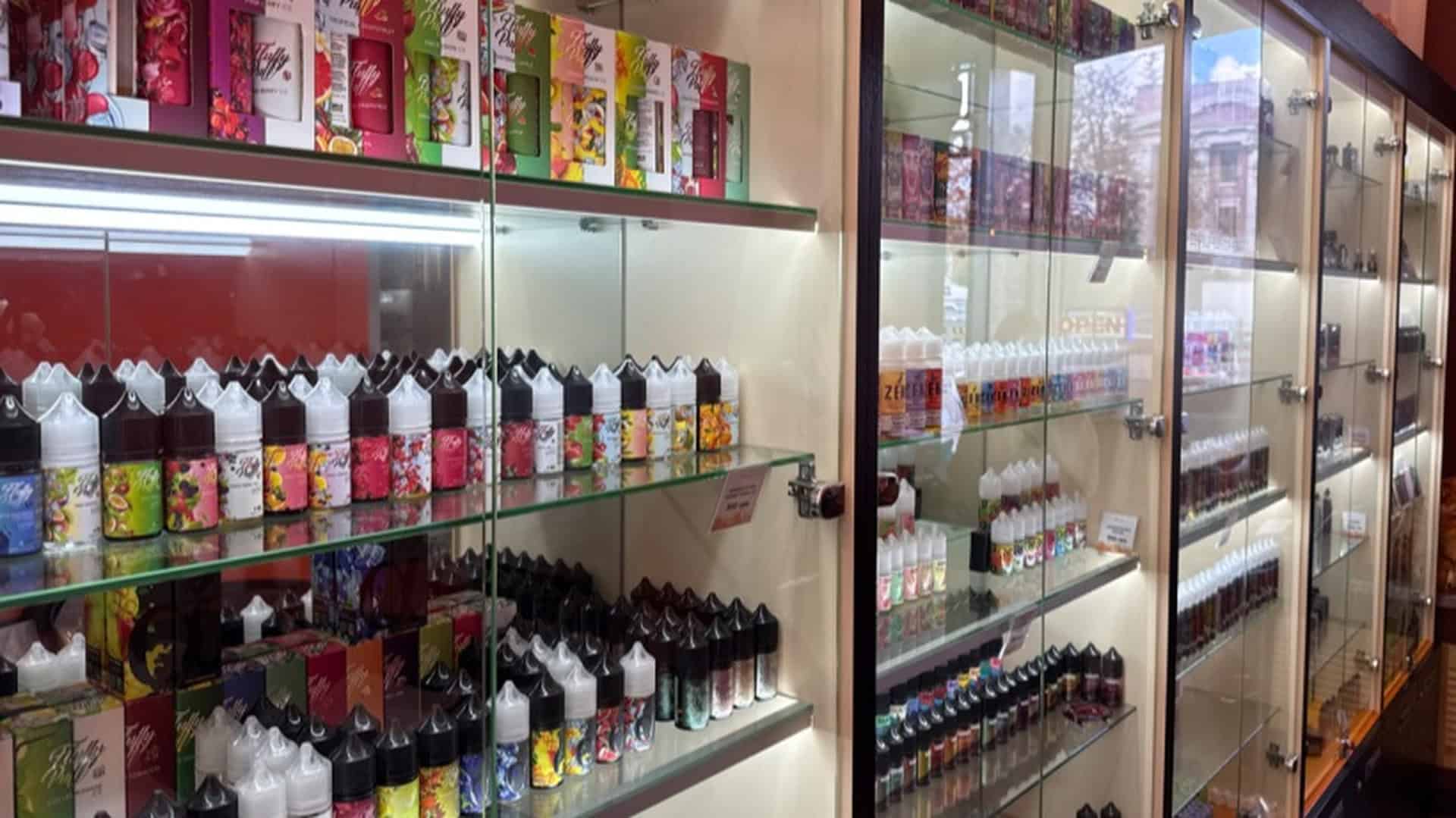 Вітрина магазину з численними ароматизованими рідинами для вейпів