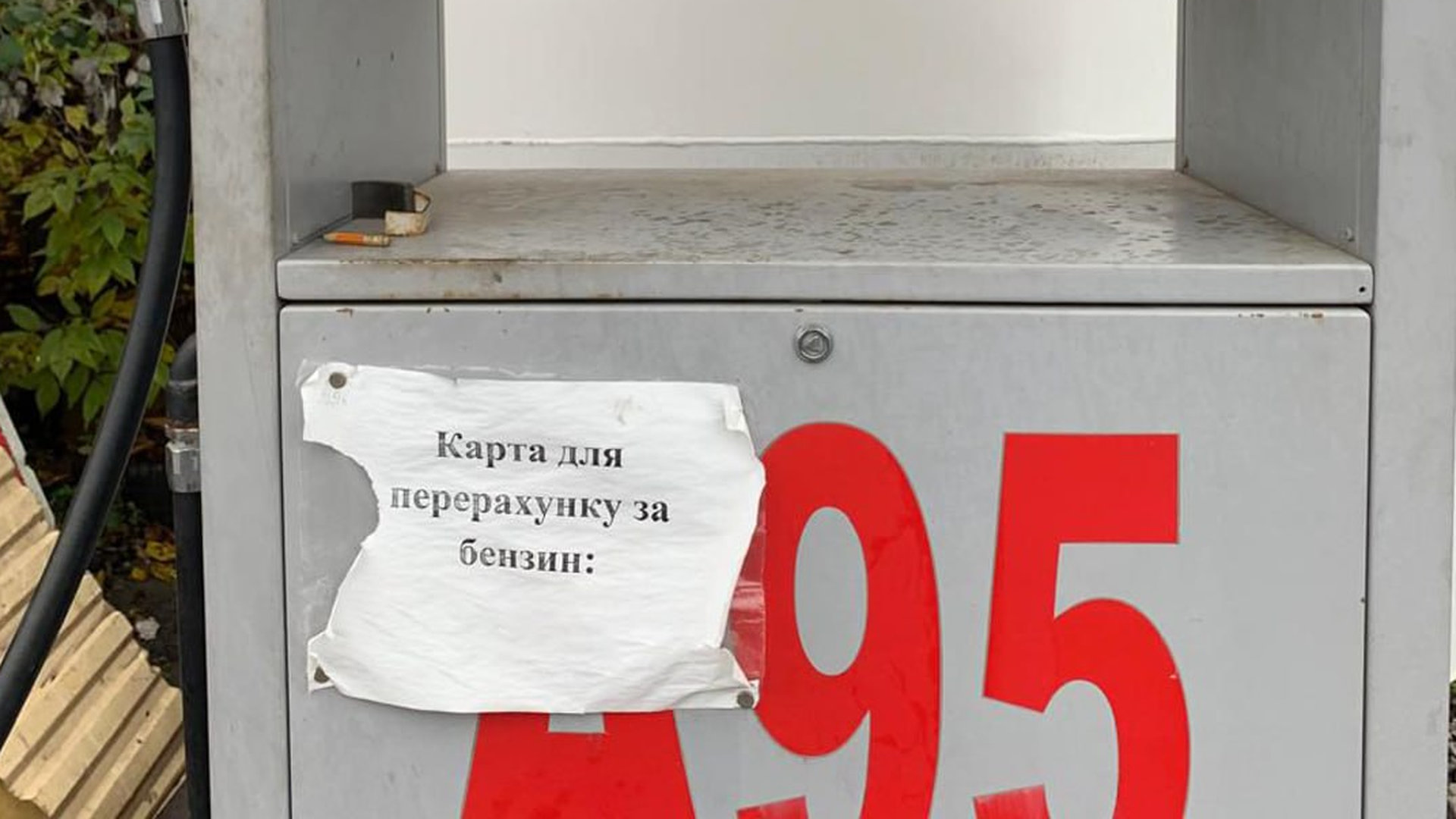 Папір з надписом про карту перерахунку для грошей наклеєний на одну з металевих конструкцій на заправці