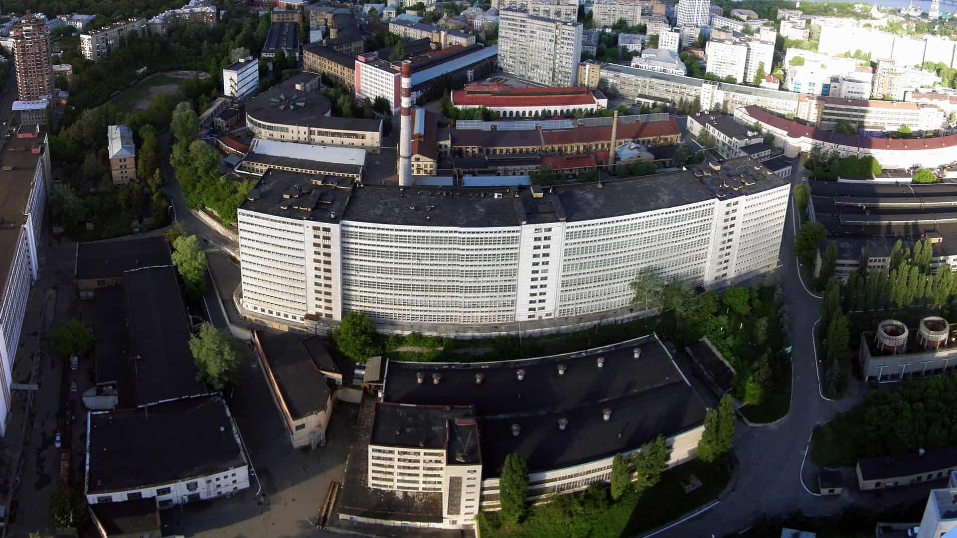 Аерофотознімок великої напівкруглої білої будівлі та промзони