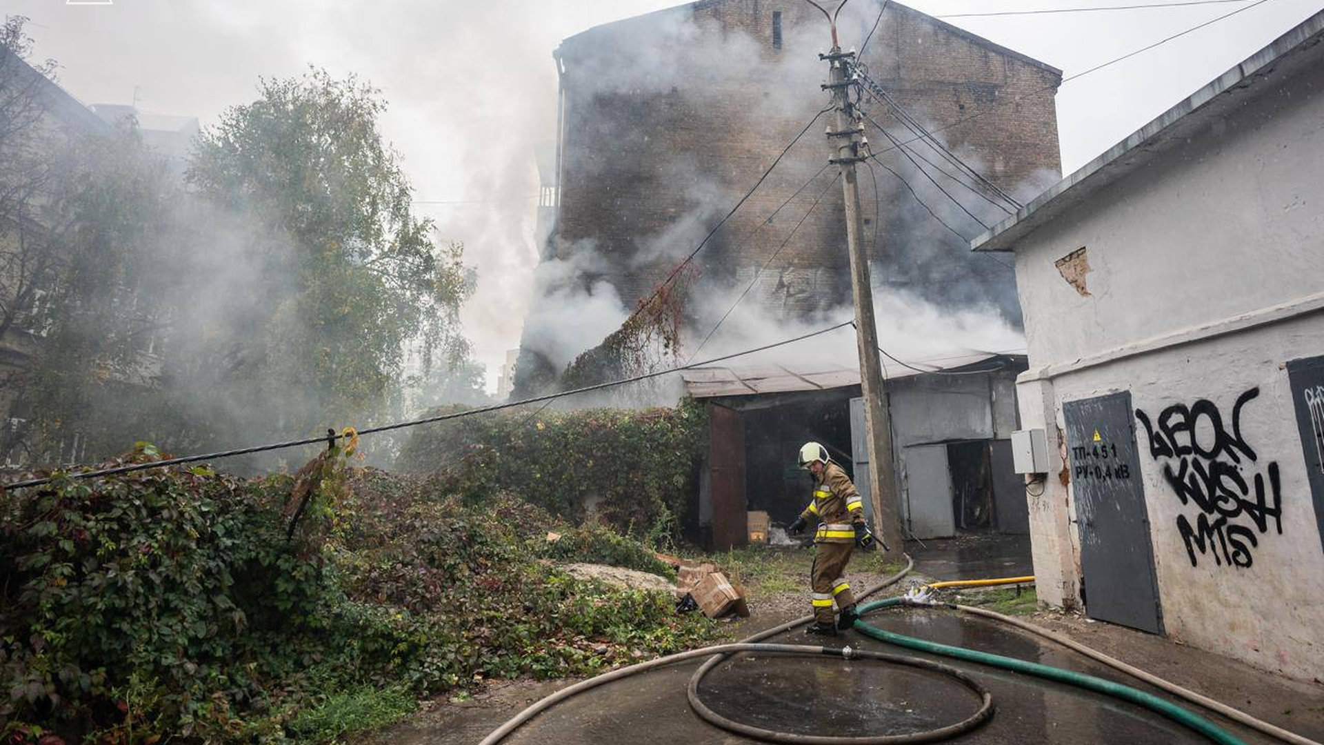 Дим і пожежа в гаражному кооперативі у Києві, працівник ДСНС гасить вогонь