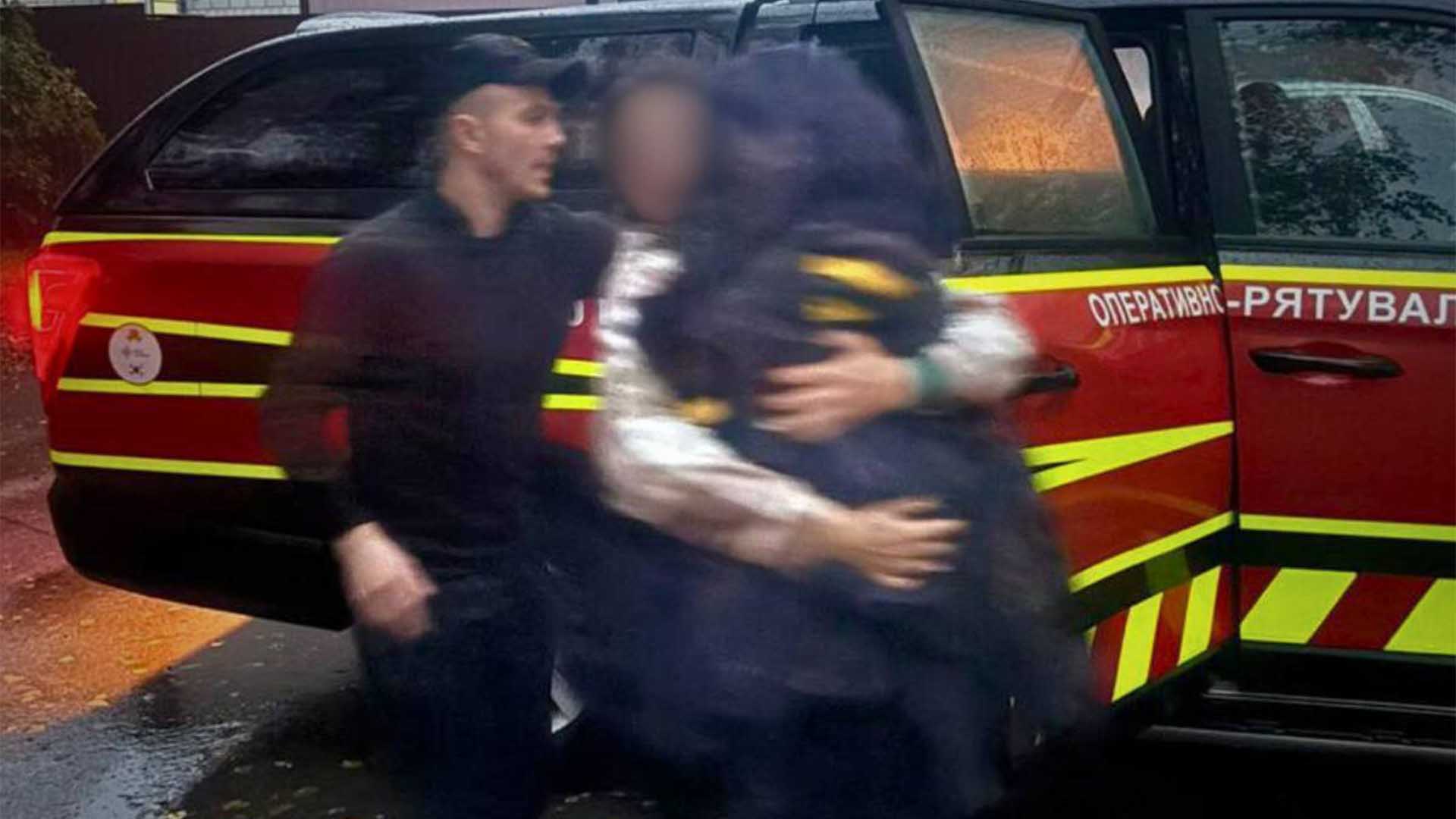 Мати тримає на руках врятованого дворічного хлопчика, виходить із автомобіля ДСНС