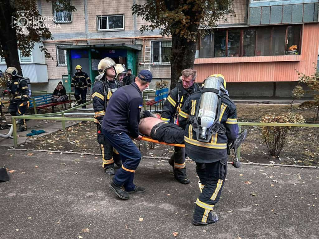 Пожежа в багатоповерхівці на Лісовому проспекті: врятовано сімох людей, серед них троє дітей (фото) Рятувальники ДСНС Києва виносять постраждалого чоловіка на ношах із палаючого будинку