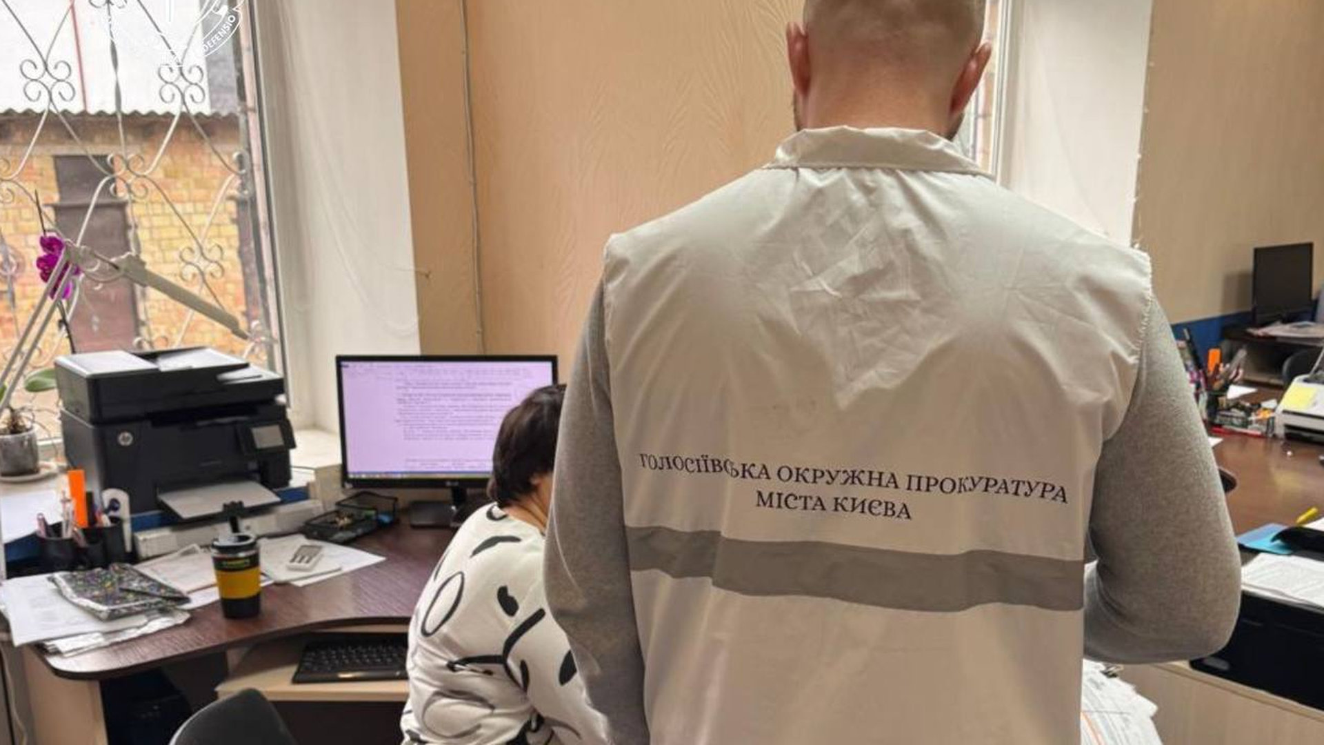 Представник міської прокуратури Києва вручає підозру чиновниці за оборудки на закупівлі ноутбуків