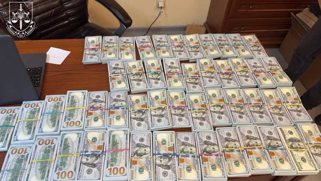 Київ: 11 осіб контрабандою ввезли годинники на 11 млн грн Доларові купюри лежать на столі