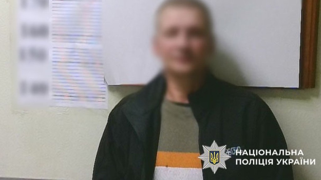 Затриманий в полціії Києва стоїть біля стіни обличчям до камери, обличчя заблюрене