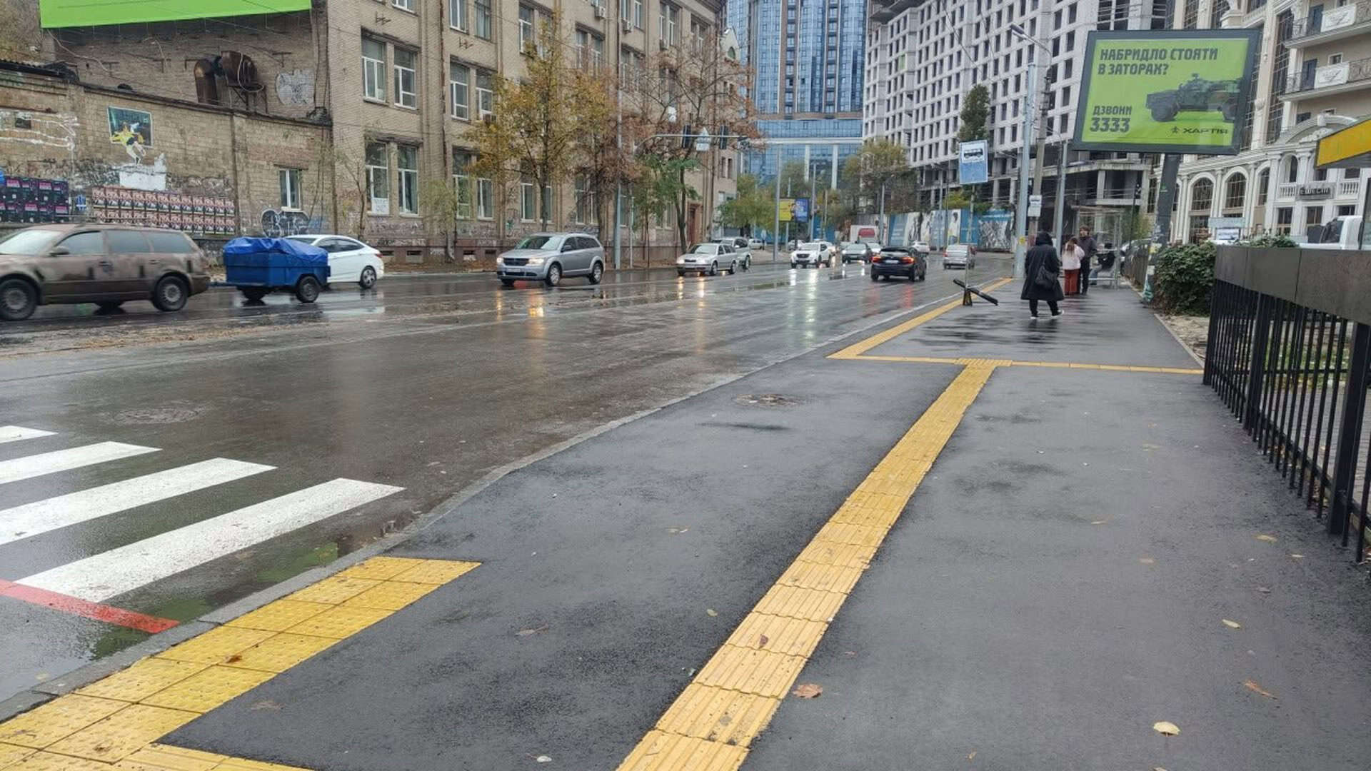 Вулиця з пішоходами та машинами після дощу