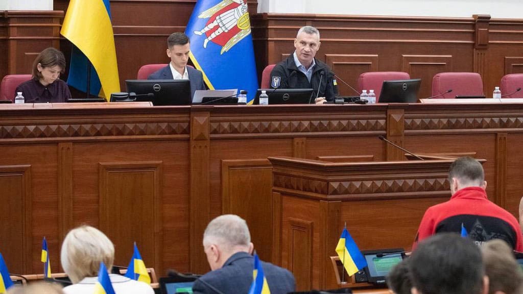 4 млрд грн для військових: Київрада має затвердити рішення Віталій Кличко головує засіданням Київської міської ради, поряд із ним сидить чоловік і жінка, також в залі присутні депутати київради