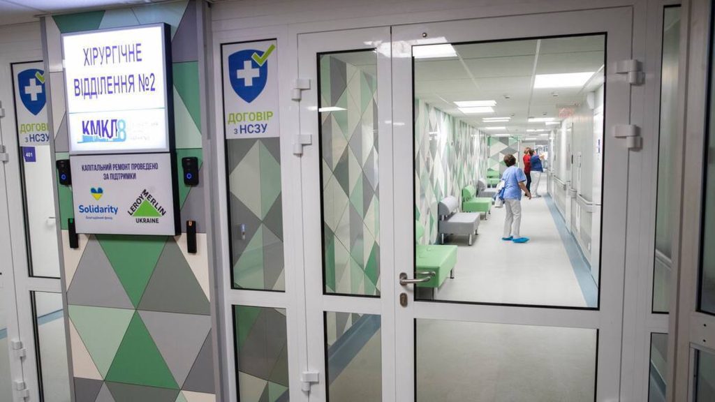 Вхідні двері до хірургічного відділення, в коридорі медсестра і пацієнти 