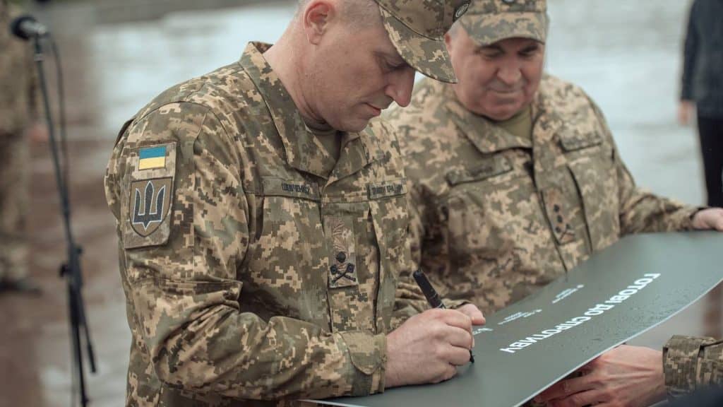 Київ: на Алеї Захисників відкрили пам’ятний знак воїнам ТРО України Двоє військових у формі підписують табличку для встановлення памʼятного знаку ТРО