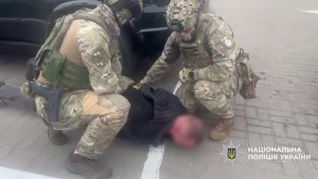 момент затримання: спецпризначенці в камуфляжі тримають чоловіка обличчям до асфальту біля автомобіля