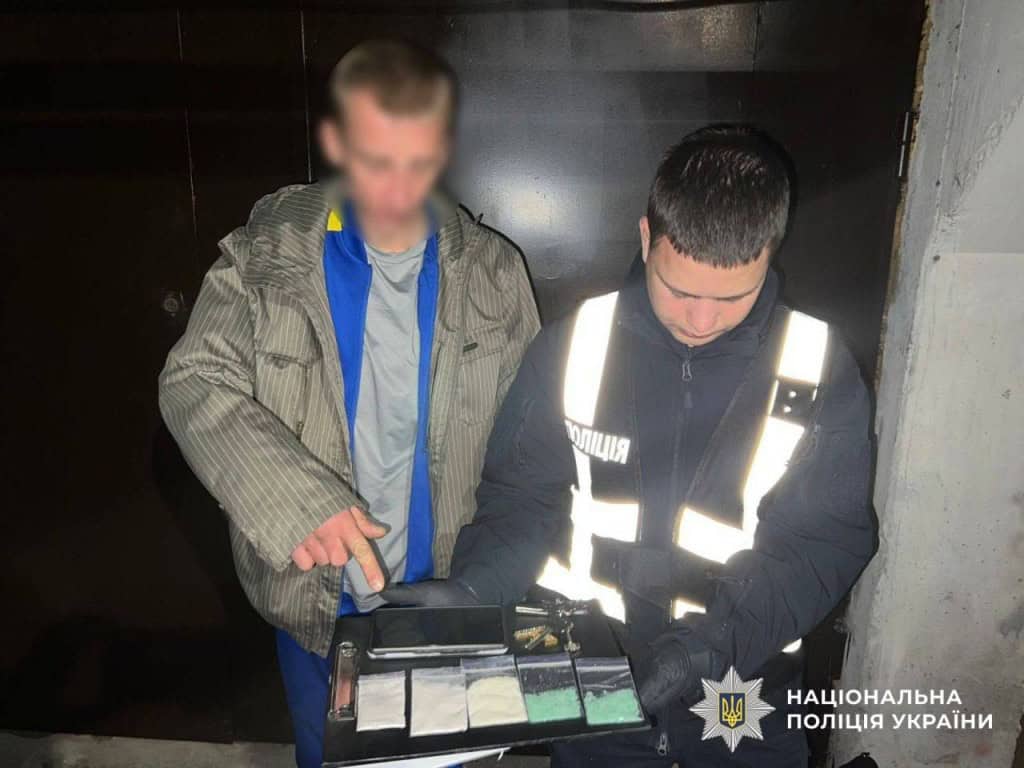 Поліцейський показує знайдені пакети з наркотиками