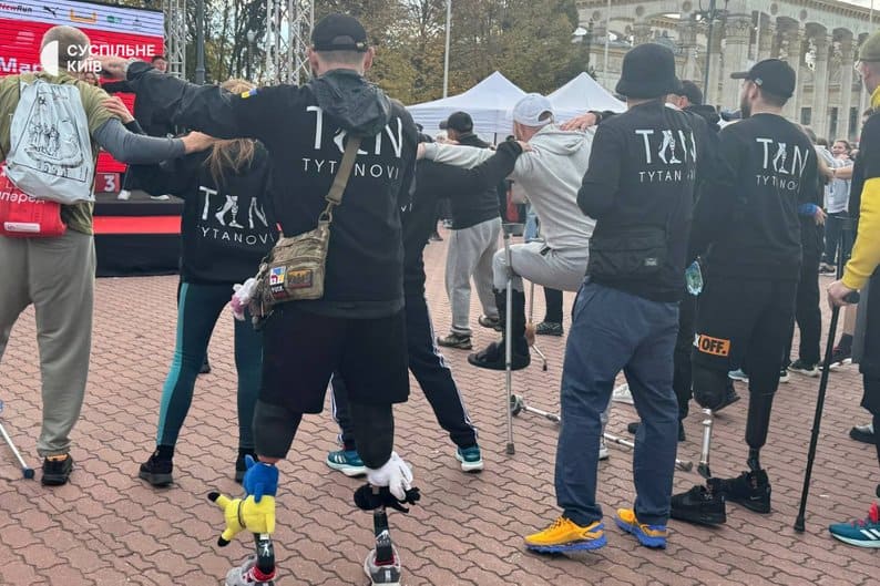 «Забіг Єдності» у Києві зібрав 4 мільйони гривень для реабілітації ветеранів (фото) Учасники з протезами стоять у колі, тримаючись за плечі