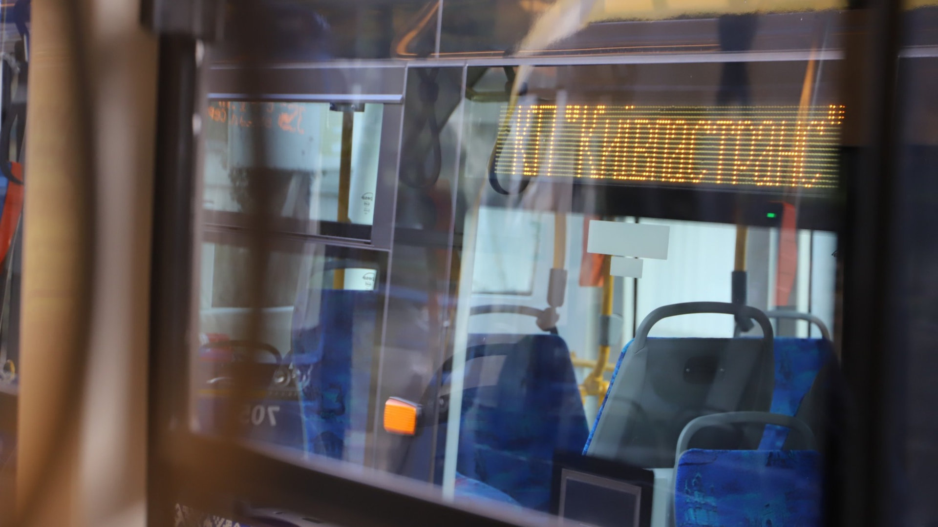 Салон тролейбуса знятий через скло, надпис Київпастранс на електронному табло і сині сидіння всередині, людей немає