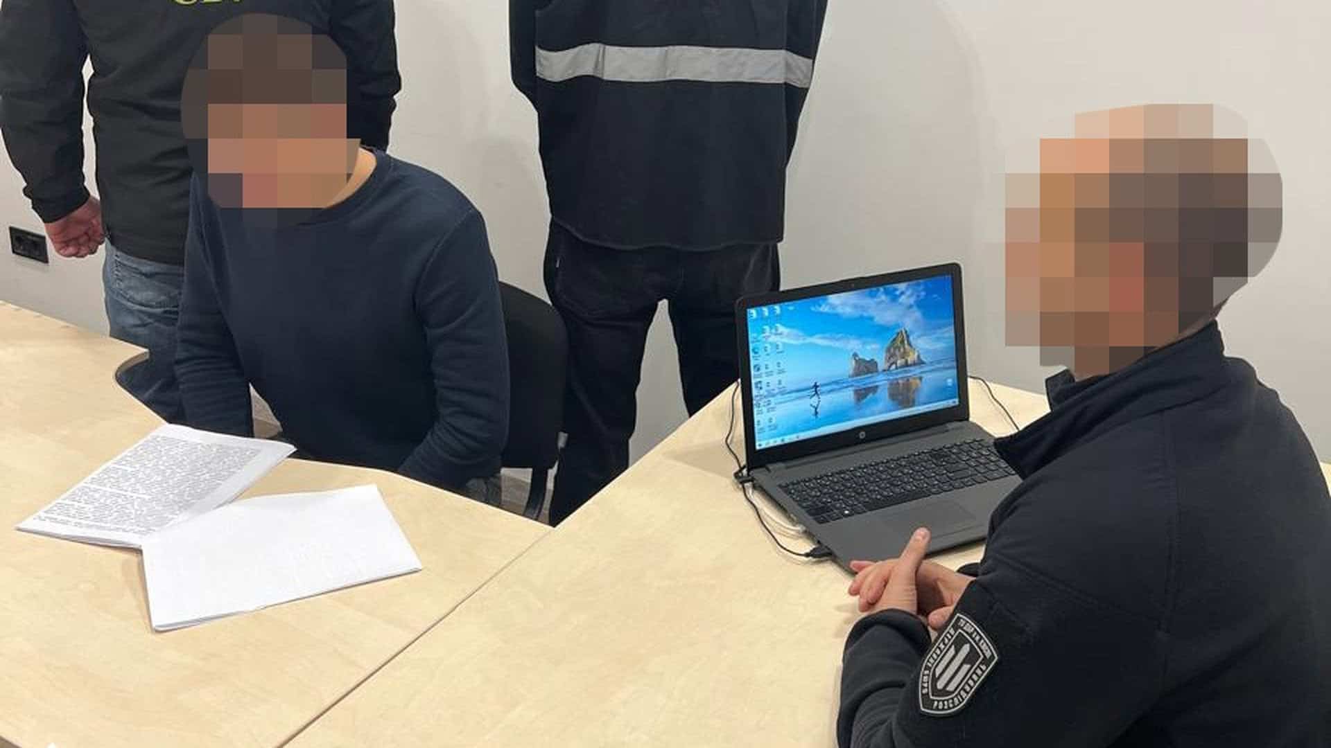 Слідчі проводять допит чоловіка в кабінеті, на столі документи й ноутбук