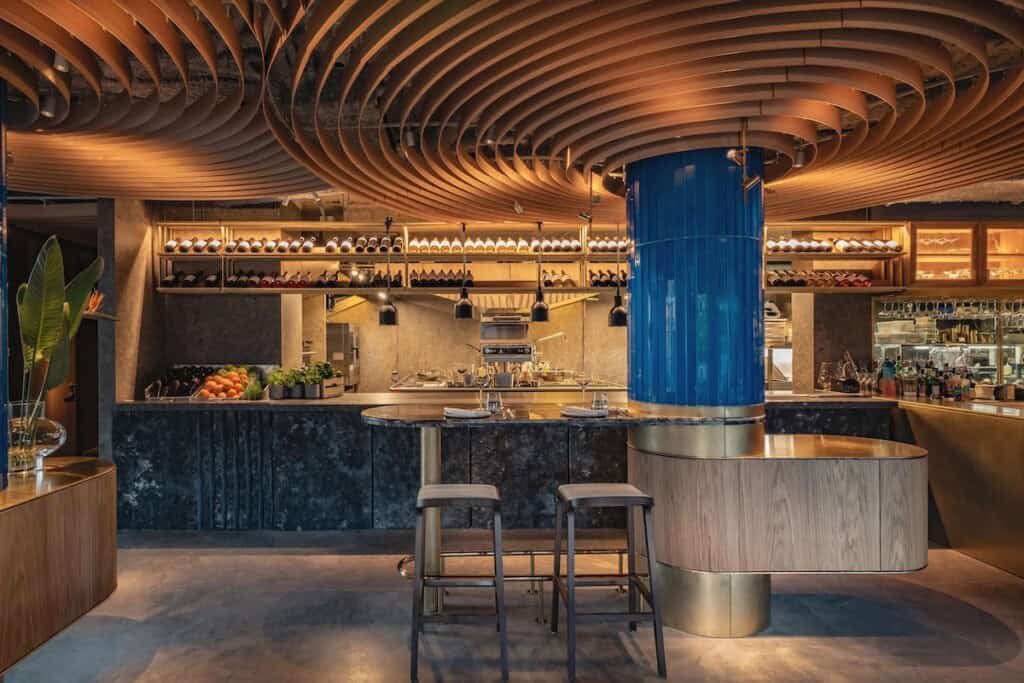 Барна зона з дерев'яною стелею та барною стійкою з мармуру