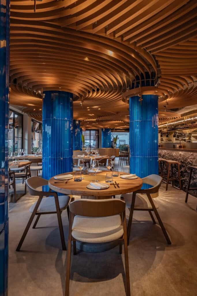 Ресторан з дерев'яною хвилястою стелею та синіми колонами