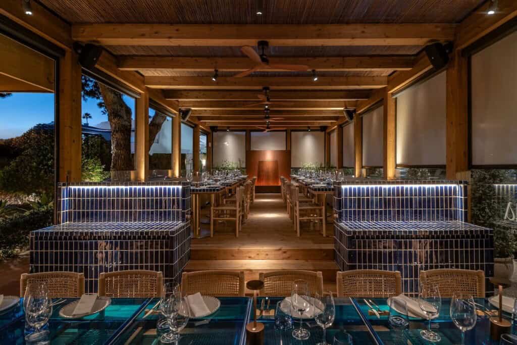 Літній ресторанний зал з синіми мозаїчними лавами та деревом