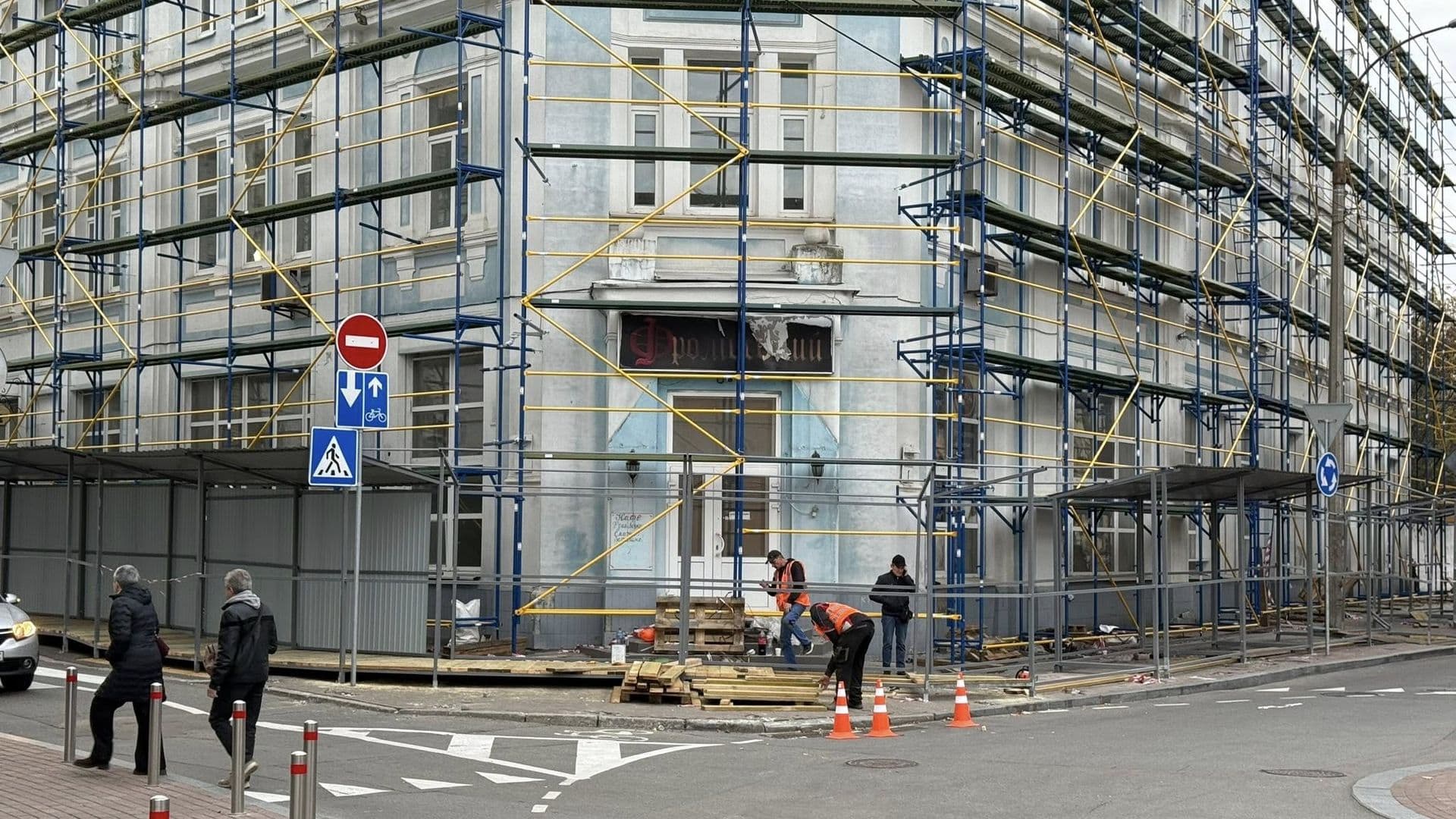 Будівля під реставрацією з будівельним риштуванням та робітниками