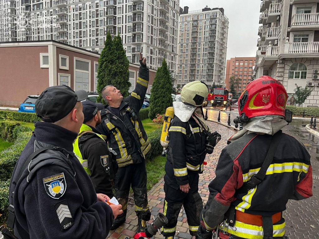 Пожежники та поліцейські обговорюють дії на місці займання біля будинку житлового комплексу «Нова Англія»