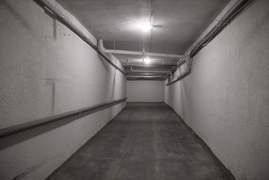 Порожній підземний коридор з білими стінами