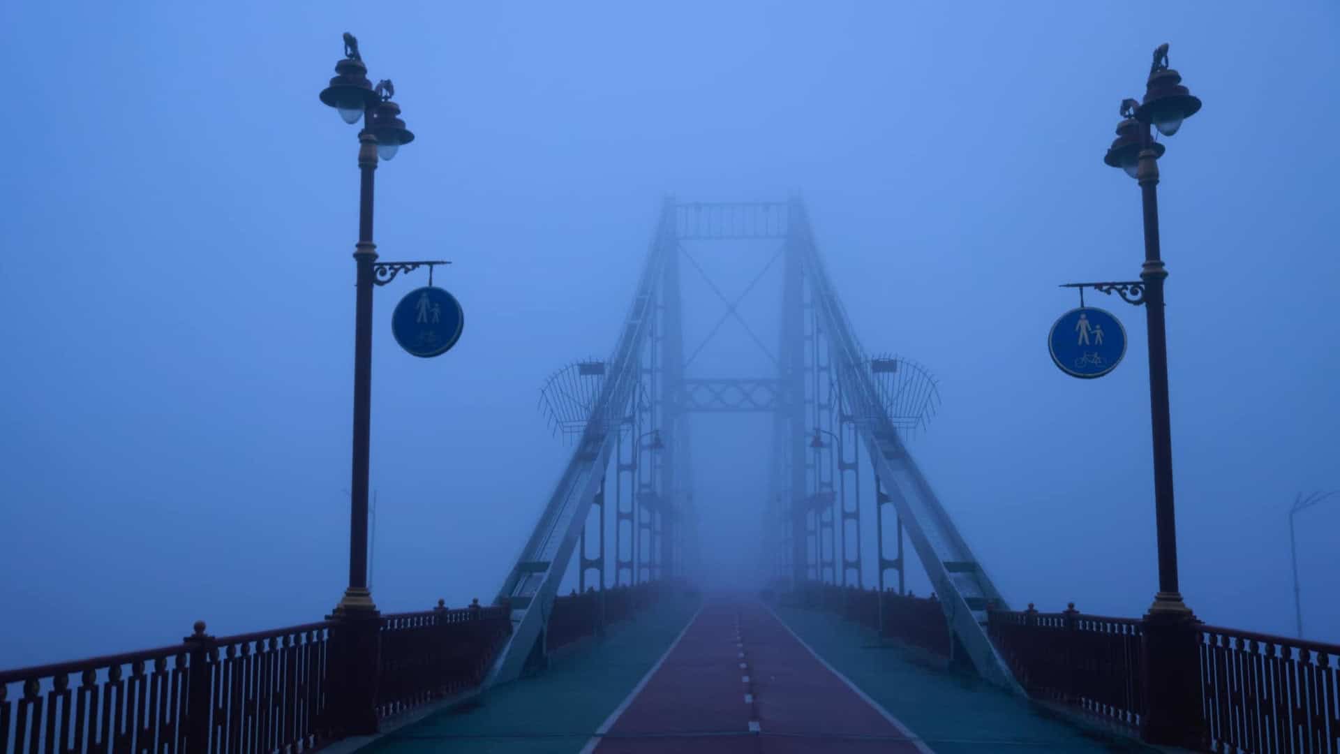 Київський пішохідний міст стоїть в тумані без людей