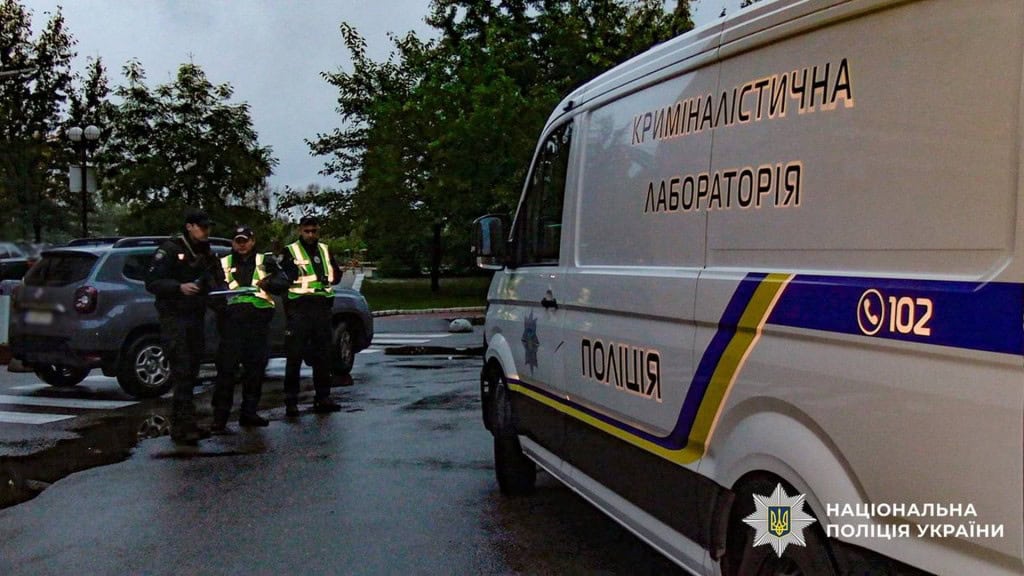 32-річний блогер знайдений мертвим на Оболоні (оновлено) Три працівники поліції стоять біля автомобіля поліції в Києві