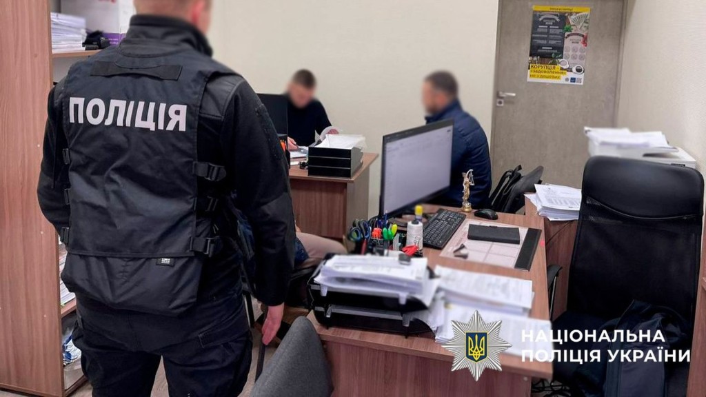 Працівники полції у поліцейському відділку допитують підозрюваного