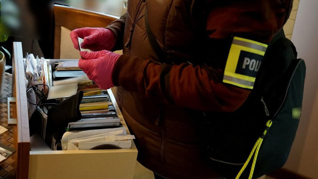 Громадянина Польщі викрили на сексуальній експлуатації 8 дітей з України Руки слідчого інспектора в рожевих рукавичках, він вивчає вміст шухляди в будинку підозрюваного