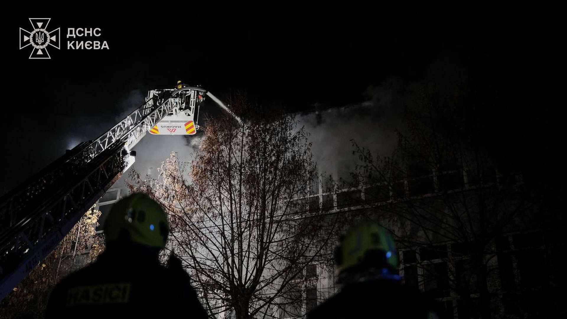 Пожежники гасять пожежу на даху будівлі вночі