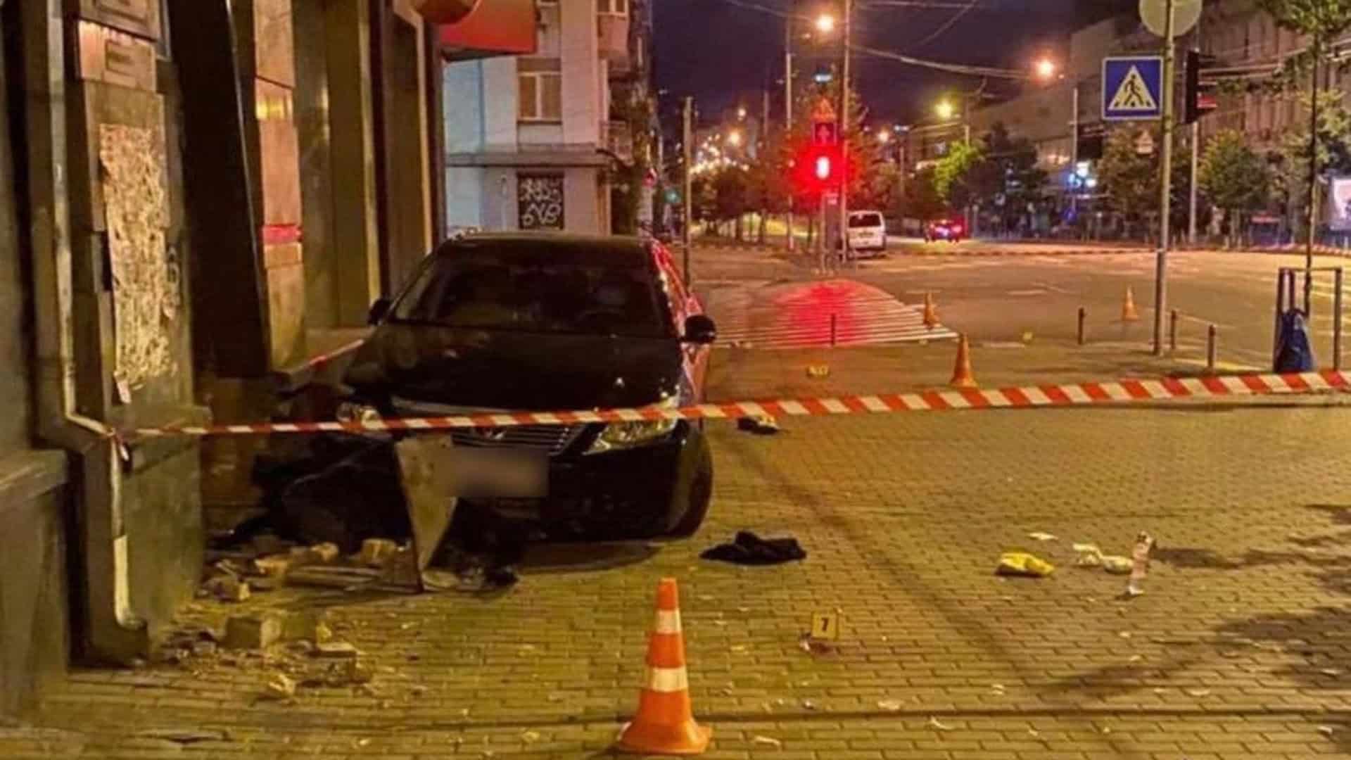 Нічна сцена ДТП у місті: чорний автомобіль врізався в стіну будівлі