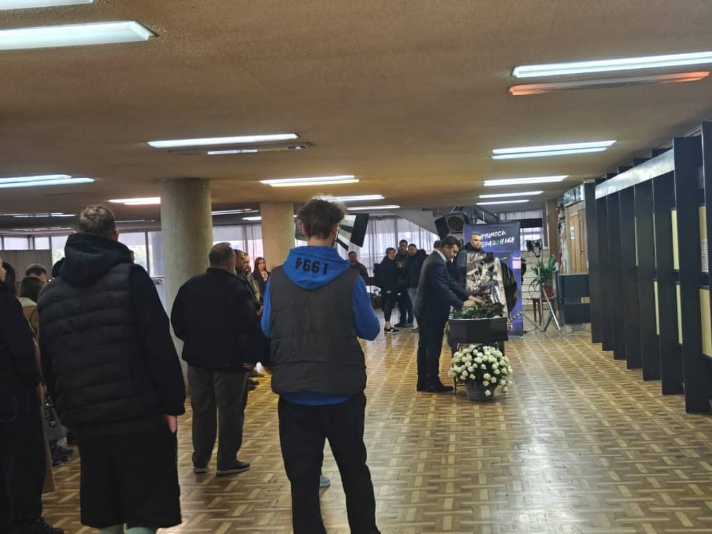 Люди всередині будівлі стоять у черзі, щоб попрощатися з музикантом