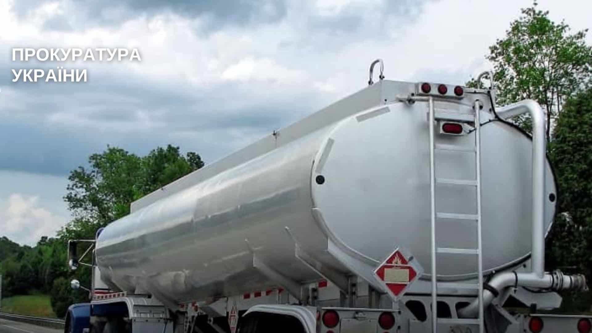 Машина-бензовоз білого кольору на фону лісосмуги