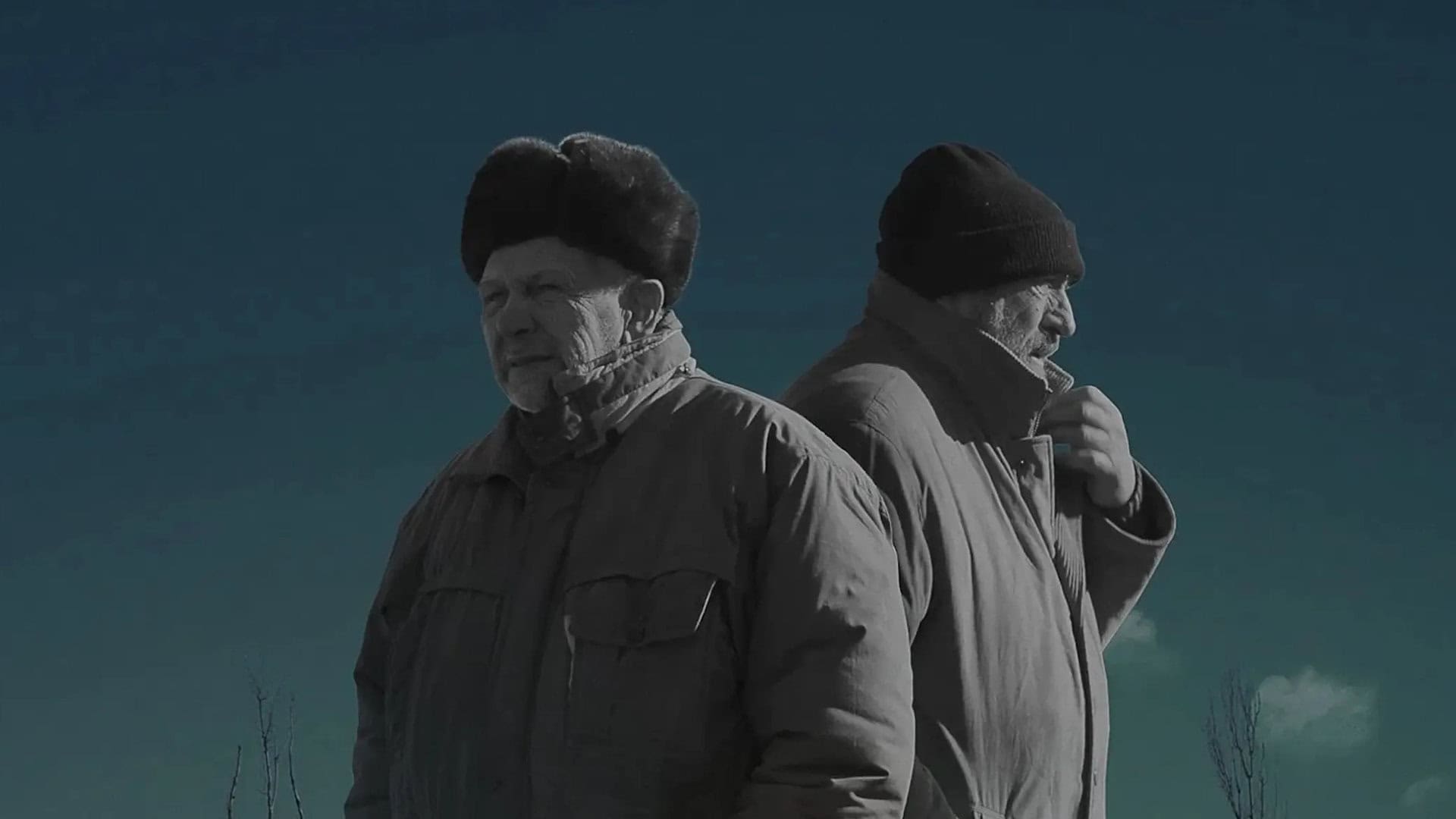 Двоє чоловіків у теплому одязі стоять спинами один до одного