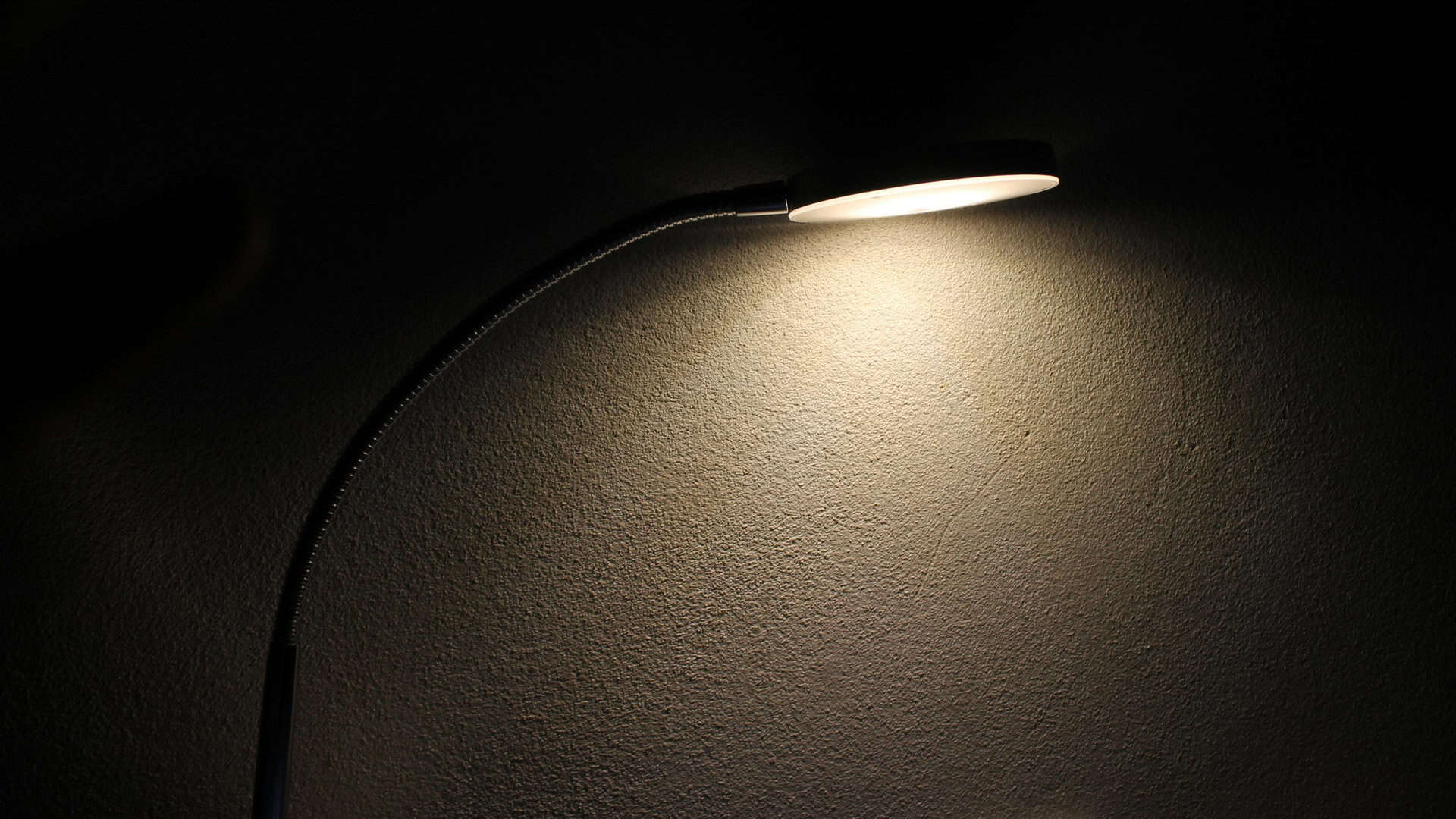 Лампа стоїть на столі і світить у повній темряві