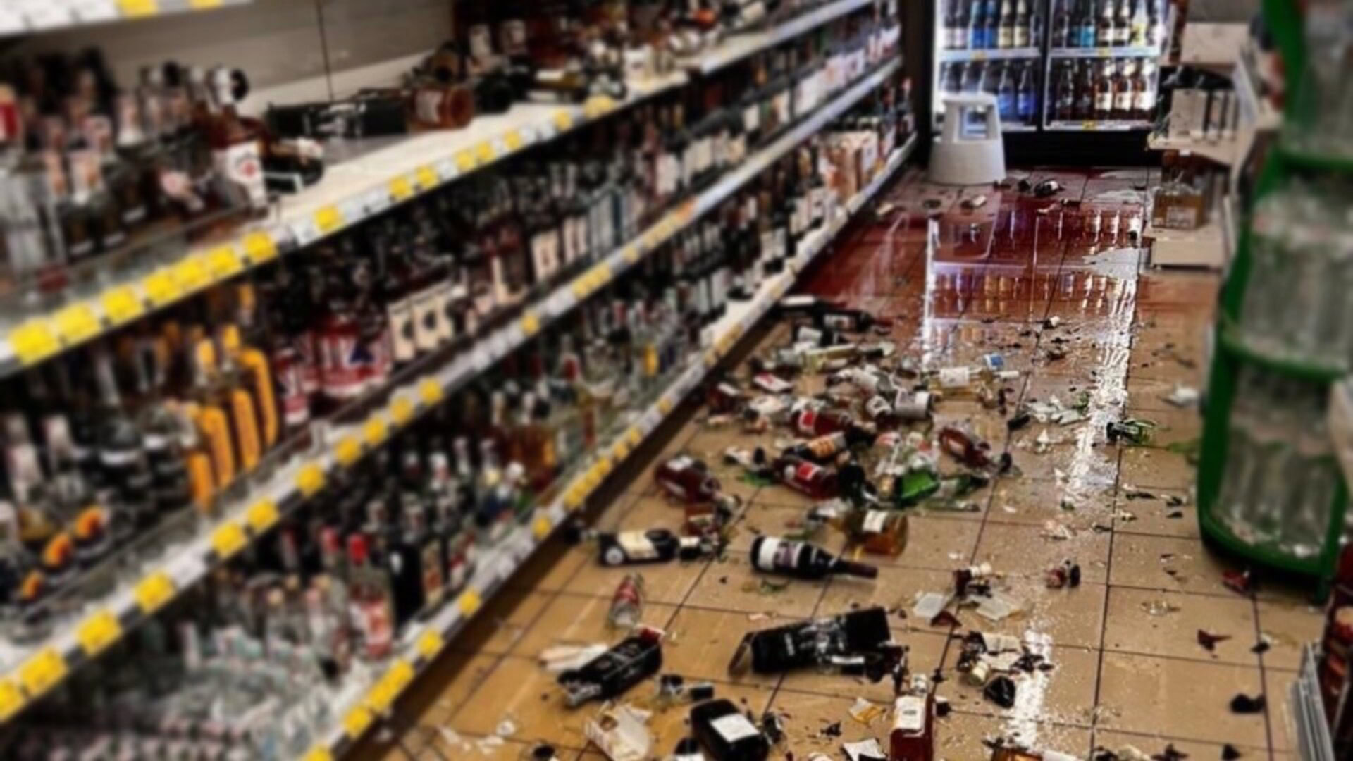 Розбиті пляшки з алкоголем на підлозі в супермаркеті