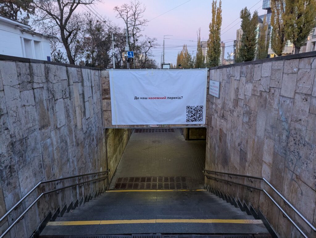 Плакат з написом «Де наш перехід?» на вході у підземний перехід біля метро «Університет»