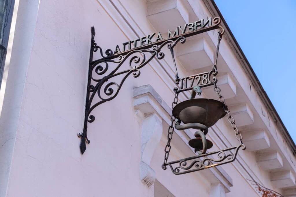 Металева вивіска Аптека музей на білій стіні будинку