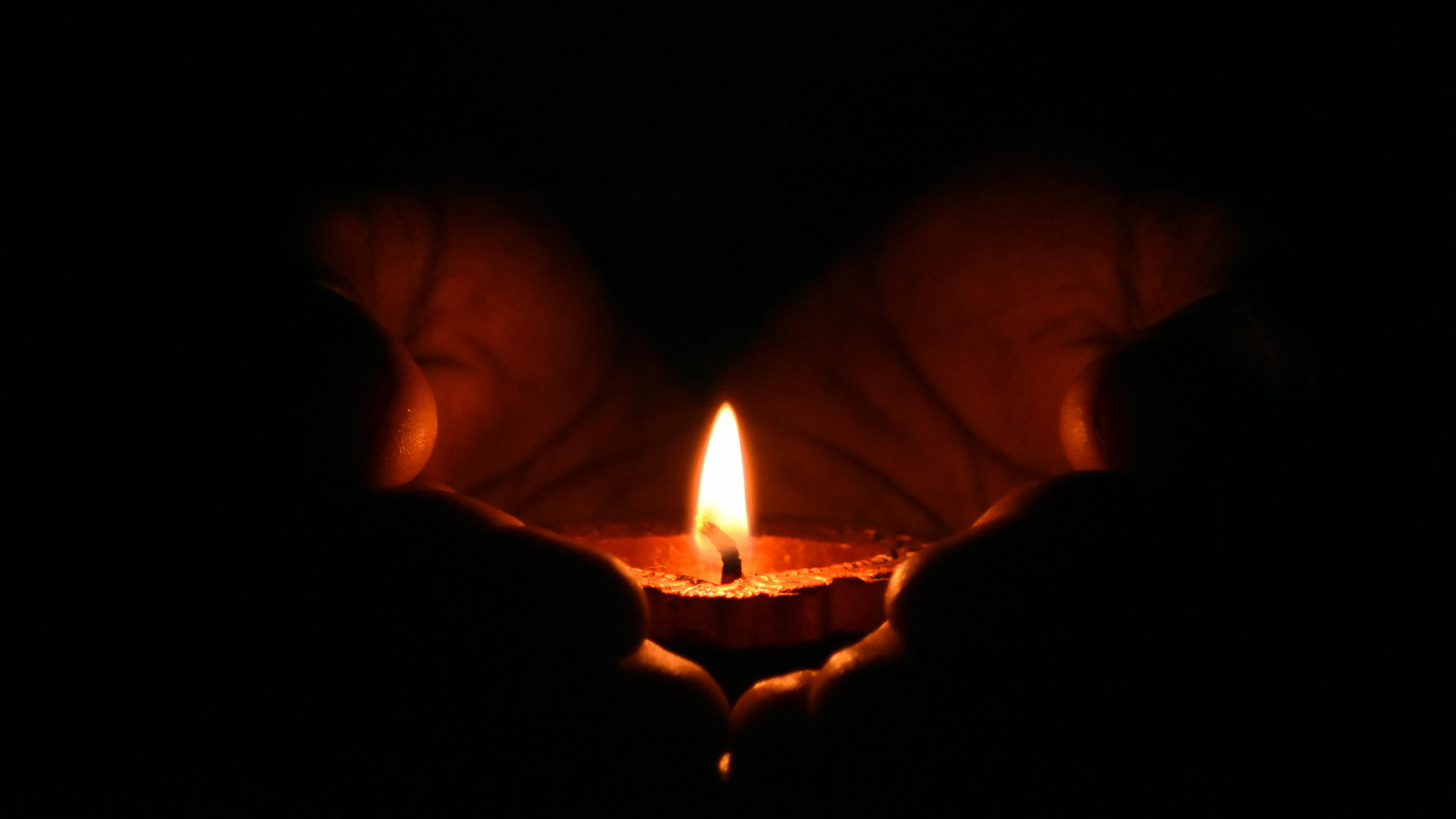 Свічка горить в руках людини