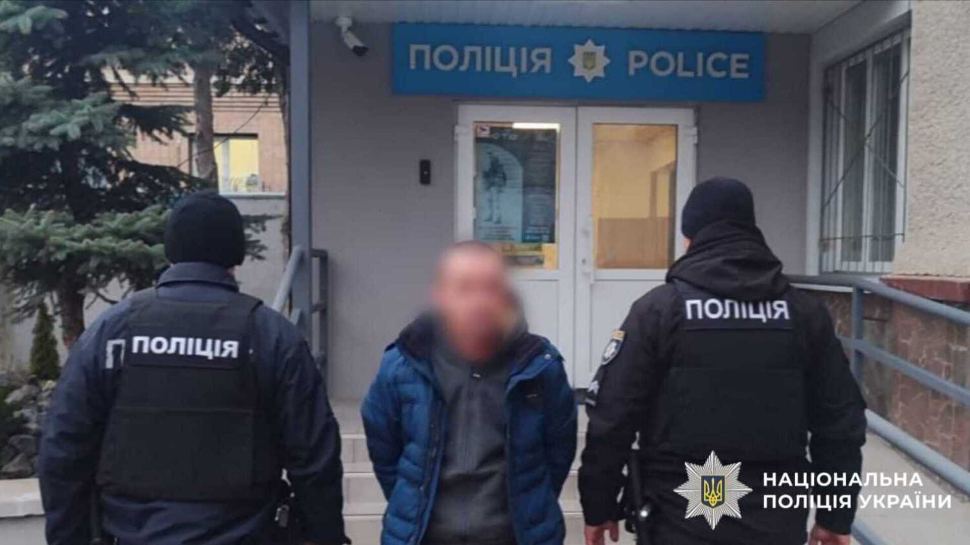 Затриманий чоловік біля двох поліцейських